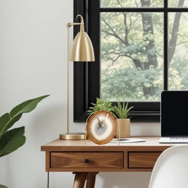 a desk with a laptop and a plant in front of a window