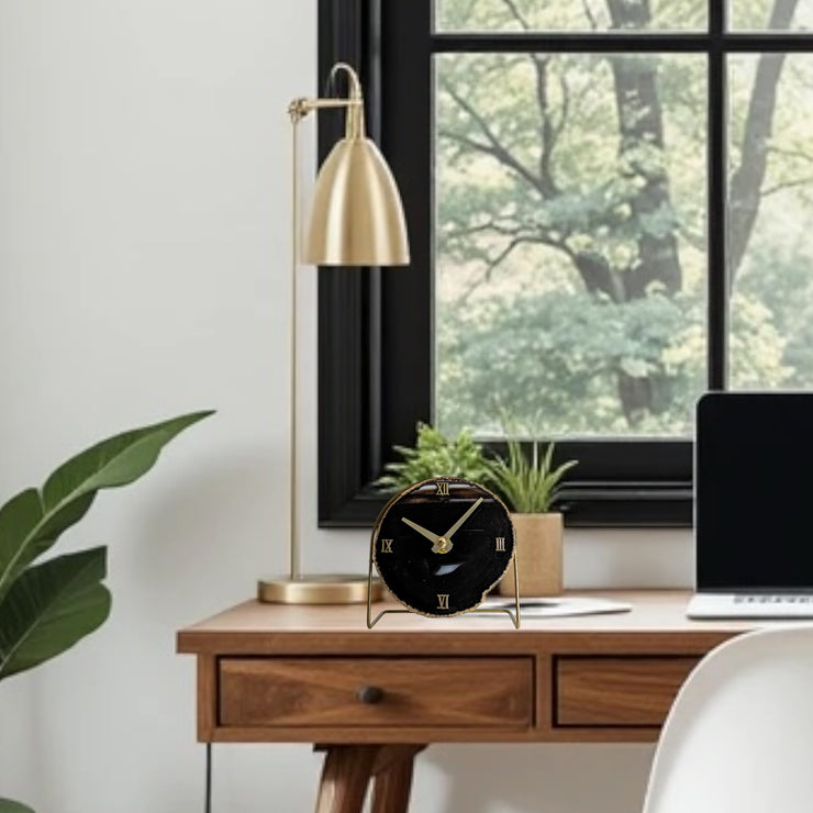 a desk with a laptop and a clock on it