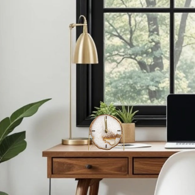 a desk with a laptop and a clock on it