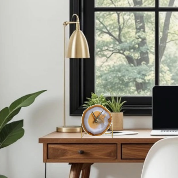 a desk with a laptop and a clock on it