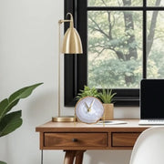 a desk with a laptop and a clock on it