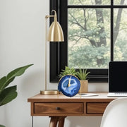 a desk with a laptop and a plant on it